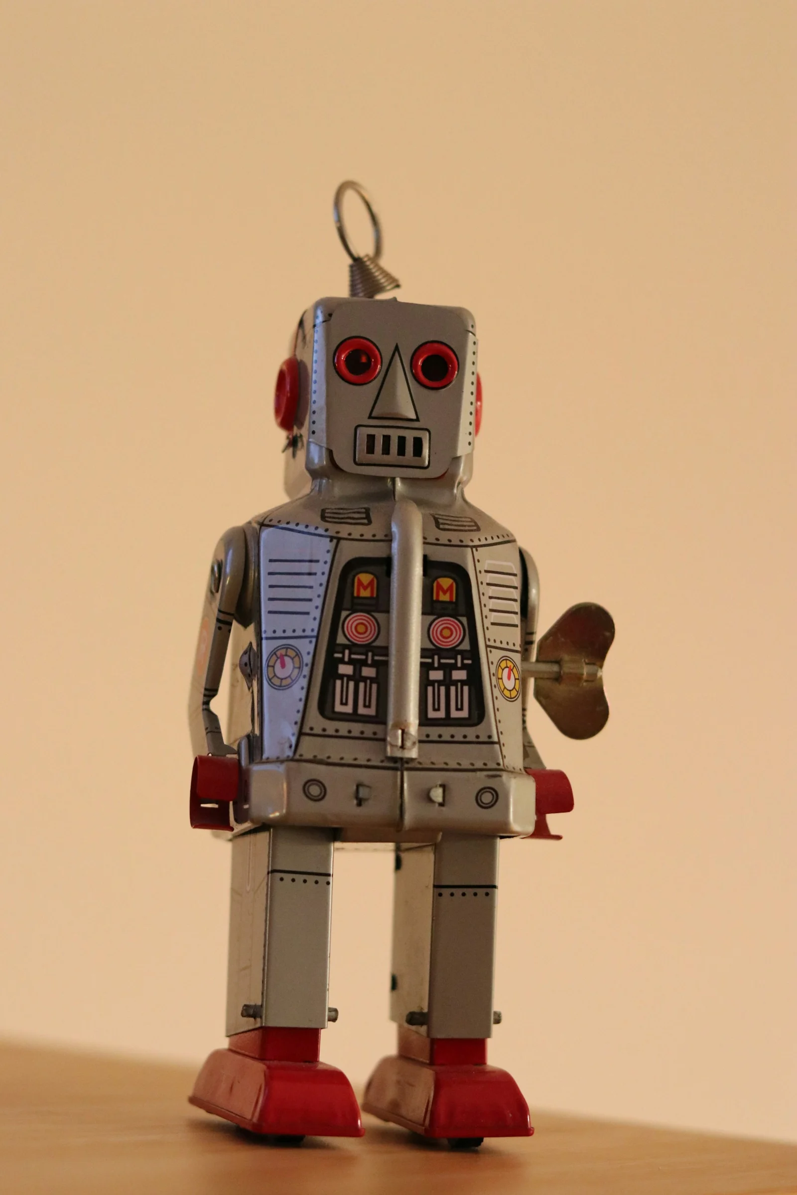A toy robot standing on top of a wooden table;第三方摄影参考